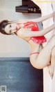 A woman in a red lingerie posing on a bed.