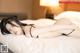 A woman laying on top of a bed in a black lingerie.