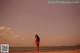 A woman in a bikini standing on a beach.