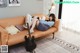A woman laying on a couch with a guitar.