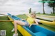 A woman sitting on top of a blue and yellow canoe.