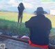 A man and a woman sitting on a train track.