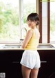 A woman standing in a kitchen next to a sink.